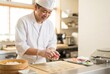 © Stitch - A smiling Japanese sushi chef happily prepares fresh nigiri, pressing rice and tuna together in a clean, professional kitchen.