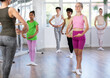 © JackF - Slender teen girl doing third position of ballet together with other juvenile participants of choreography classes