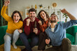 © Miljan Živković - Friends cheering and celebrating victory watching sports at home