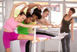 © JackF - Group of teenage dancers doing stretching exercises at barre in dance studio