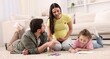 © New Africa - Pregnant woman, her husband and daughter drawing together on floor at home