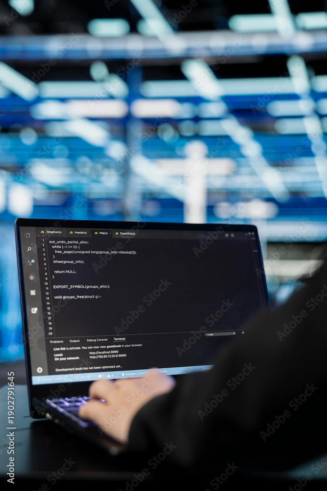 Close up of data center programmer coding on laptop to upgrade datasets ...
