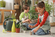 © Pixel-Shot - Cute children taking care of plants on floor in workshop