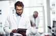 © Hinrichsen/peopleimages.com - Medical, scientist and man with tablet in laboratory for report, review and cure development. Technology, science worker and serious person with online study, experiment records and pharma research
