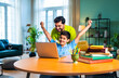 © StockImageFactory - Indian asian kid studying on laptop at home while father guides him patiently
