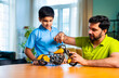 © StockImageFactory - Indian father helping kid repair toy using screw driver at home