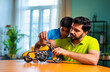 © StockImageFactory - Indian father helping kid repair toy using screw driver at home