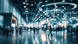 © CStock - A blurred image of people engaged in a busy exhibition or trade show, filled with bright lights and activity.