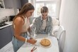 © svetograph - Birthday Cake Sisters Kitchen: Two sisters prepare a birthday cake in their kitchen for a celebration.