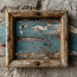 © Evdoha - A textured vintage background featuring an empty wooden frame on an old plaster wall with peeling blue paint.