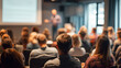 © Annamorphosis - Audience watches a trainer presenting at a corporate seminar with a projector