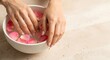 © antuanetto - Female hands enjoying a relaxing hand bath with delicate rose petals in water, a serene self-care and beauty concept for rest and wellness