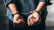 © Bonsales - Hands restrained with metal handcuffs, symbolizing the concepts of arrest, criminal justice, punishment, and the legal system