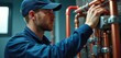 © miss irine - Man in blue cap works on copper pipes. He adjusts a connection on modern heating system. Technician services gas boiler installation at indoor location.