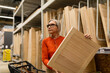 © Ivan Traimak - Woman shopping for wooden panels in a home improvement store during the daytime