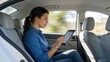 © Mason - Woman using tablet in car