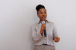 © Komora - Black woman public speaker holding microphone presenting to an audience, standing for a business conference