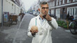 © Krakenimages.com - Man doctor in labcoat holding brain and points finger at camera on street; medical warning seriousness.