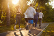 © Studio Romantic - Runners training, young people running marathon together through green park in sunrise. Back view of athletes team enjoying jogging workout with high motivation and energy, fitness teamwork outdoors
