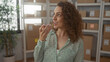 © Krakenimages.com - Woman holding smartphone to mouth in building office surrounded by parcel boxes and shelving; small business productivity.