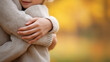 © Tetyana - Child receiving a comforting hug, wrapped in a warm sweater, enjoying the golden autumn light, feeling secure and loved in an outdoor family moment, copy space