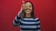 © Krakenimages.com - Young hispanic woman smiling with thumbs up gesture against isolated red background