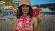 © Krakenimages.com - Woman holding italian passport smiling at beach wearing lei and bikini outdoors during vacation in sunny weather