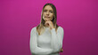 © Krakenimages.com - Young woman with long blonde hair poses thoughtfully against a vibrant pink background, wearing a white shirt and expressing contemplation.
