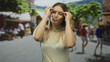 © Krakenimages.com - Young woman making exaggerated gestures in a lively city street, surrounded by blurred people, conveying surprise and emotion in an outdoor urban environment.