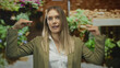 © Krakenimages.com - Woman gesturing energetically with hands in city street setting, wearing casual attire, surrounded by vibrant urban greenery, expressing lively outdoor communication.