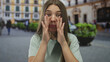 © Krakenimages.com - Teenage caucasian girl cups hands on mouth in a crowded outdoor street plaza; enthusiasm connection.
