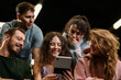 © Nikola Spasenoski - Group of friends enjoying fitness highlights on a phone in a gym setting during the day