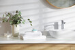 © New Africa - Stack of clean towels and cosmetic products on vanity in bathroom