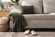 © New Africa - Slippers near stylish sofa with pillow and plaid at home