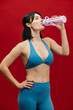 © wedmoments.stock - Healthy lifestyle scene with sporty woman drinking water on isolated background.