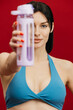 © wedmoments.stock - Fitness woman holding water bottle after workout on isolated background. Healthy lifestyle concept.