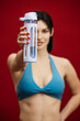 © wedmoments.stock - Athletic woman with water bottle on isolated background. Fitness training and hydration concept.