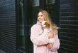 © Asya Molochkova/Stocksy - Woman Holding Small Dog Near Modern Building Exterior