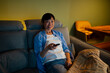 © Artcore Studio/Stocksy - Asian woman relaxing watching tv using remote control
