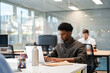 © Santi Nuñez/Stocksy - Young man using laptop working in modern office