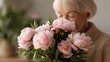 © KARINA - A old woman is smelling a bouquet of pink flowers