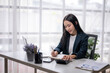 © Wasana - Young professional woman working at desk