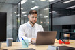 © Santi Nuñez/Stocksy - Young businessman working at laptop in modern office