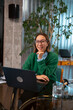 © Artcore Studio/Stocksy - Confident businesswoman working on a laptop in a modern office