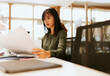 © VICTOR TORRES/Stocksy - Focused asian woman reviewing documents at her desk