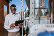 © VICTOR TORRES/Stocksy - Engineer inspecting HVAC equipment with tablet outdoors