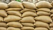 © IzzExpert - A tall protective wall made of many tightly stacked sandbags in a uniform arrangement