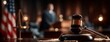© Snowstudio - Judge's gavel on desk in courtroom with blurred lawyer speaking