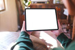 © Farknot Architect - Mockup image of a woman holding digital tablet with blank white desktop screen in cafe