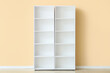 © Pixel-Shot - Empty white shelf unit near beige wall in room